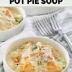Chicken pot pie soup with puff pastry, carrots, potatoes, and peas.
