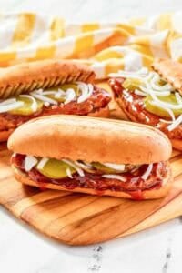 Copycat McDonald's McRib sandwiches on a wood platter.