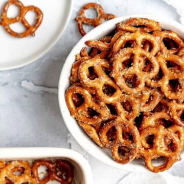 Homemade ranch pretzels in a small bowl, on a plate, and in a baking dish.
