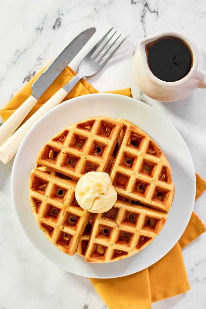 A cozy breakfast of waffles with butter and syrup.