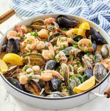 Copycat Silver Legacy Casino seafood pan roast and a kitchen towel on a marble surface.