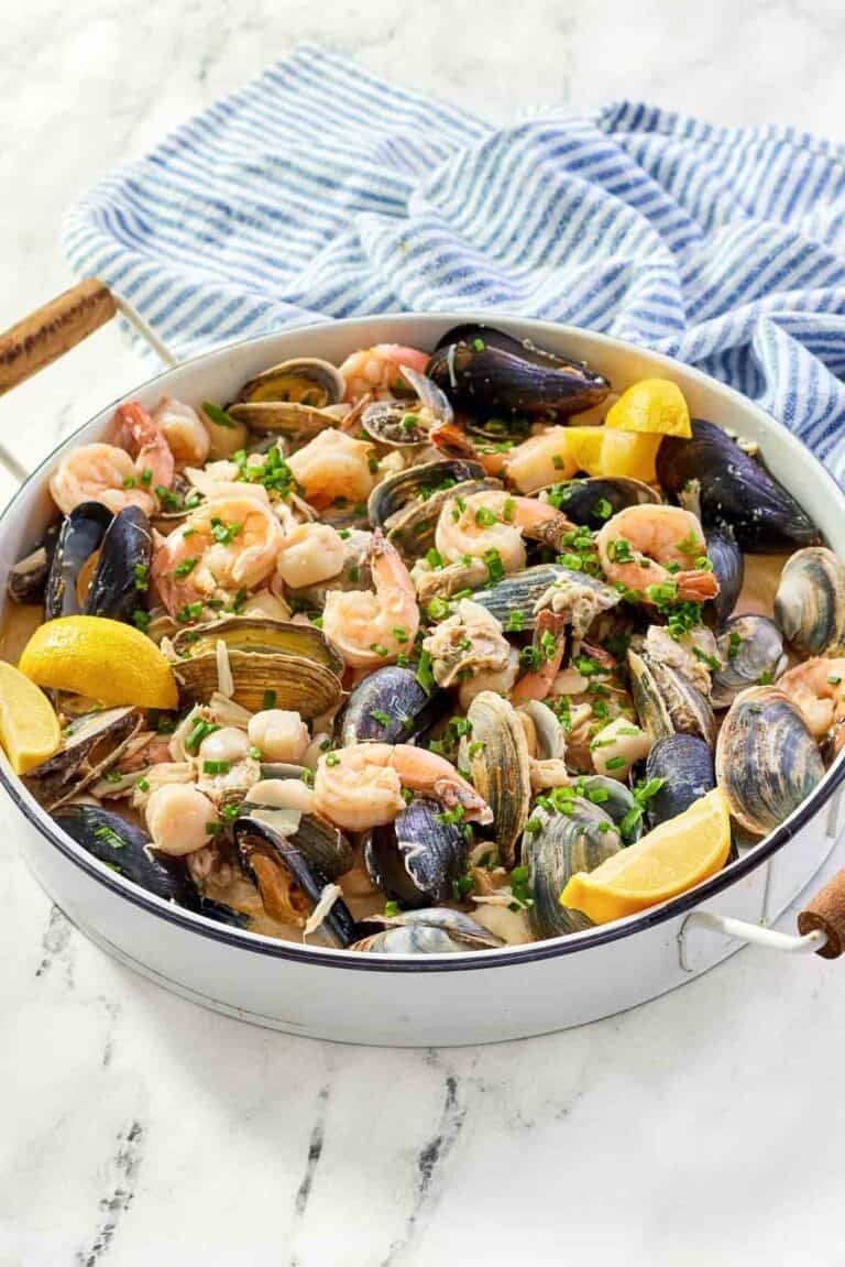 Copycat Silver Legacy Casino seafood pan roast and a kitchen towel on a marble surface.