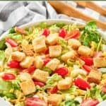 Homemade Texas Roadhouse house salad, salad tongs, and a kitchen towel.