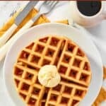Fluffy waffles topped with butter and syrup served for breakfast.