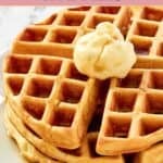 Closeup of waffles topped with butter and syrup.