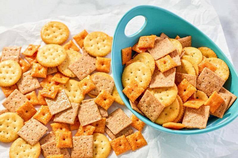 Assorted crackers seasoned with Ranch in a bowl and scattered beside it.