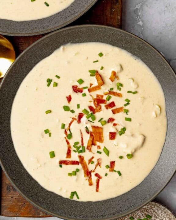 Cheese soup with beer and bacon garnished with bacon bits and chives.