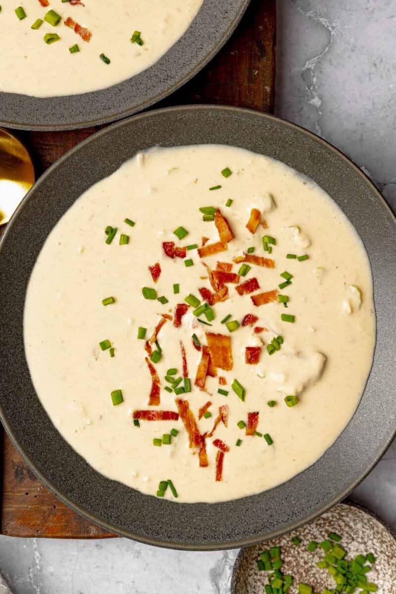 Cheese soup with beer and bacon garnished with bacon bits and chives.