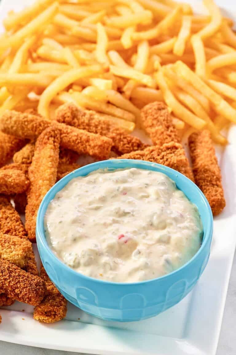 A fish sticks platter with fries and tartar sauce.