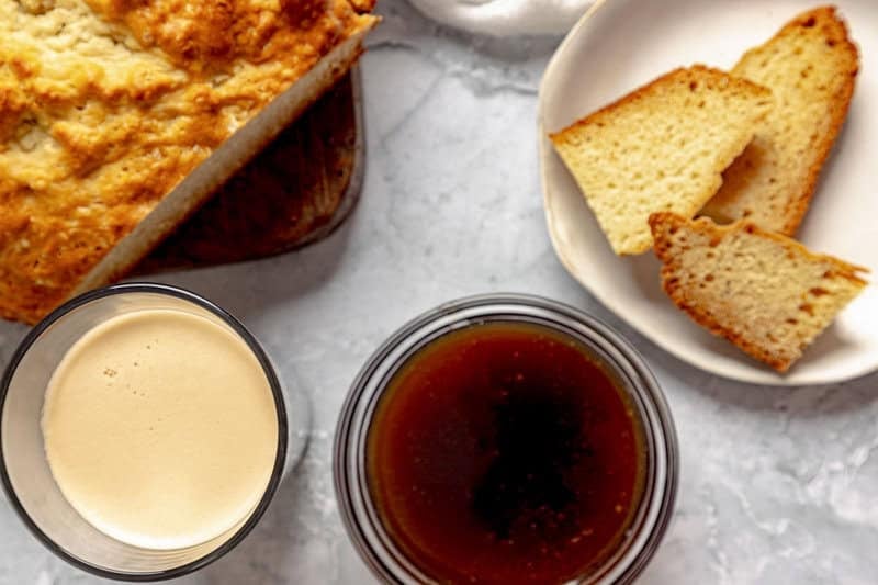 A glass of Guinness stout, Irish soda bread, and dipping sauce on a table.