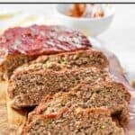 Thick slices of meatloaf on a wood cutting board.