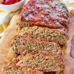 Glazed meatloaf with several slices cut from it.