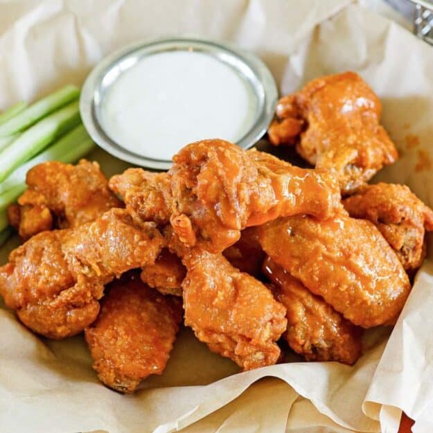 Buffalo chicken wings with celery and dipping sauce.