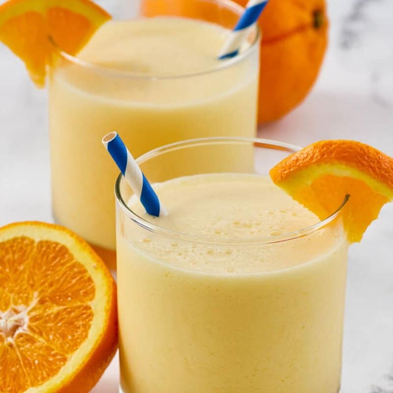 Orange creamsicle drinks with blue striped straws.
