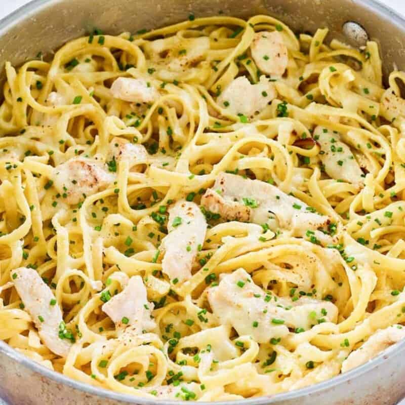 Long noodles with herbs in a pan.