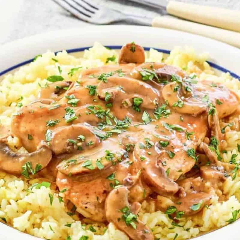Chicken and rice with parsley on top.