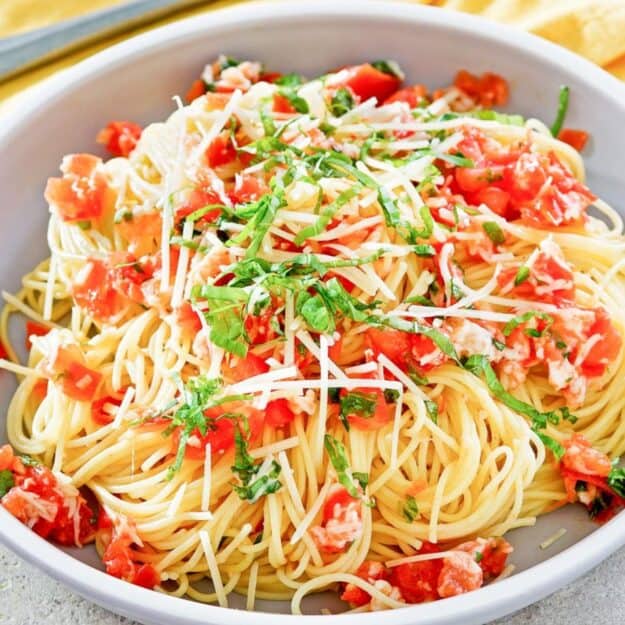 Spaghetti with tomatoes, parmesan and sliced basil.