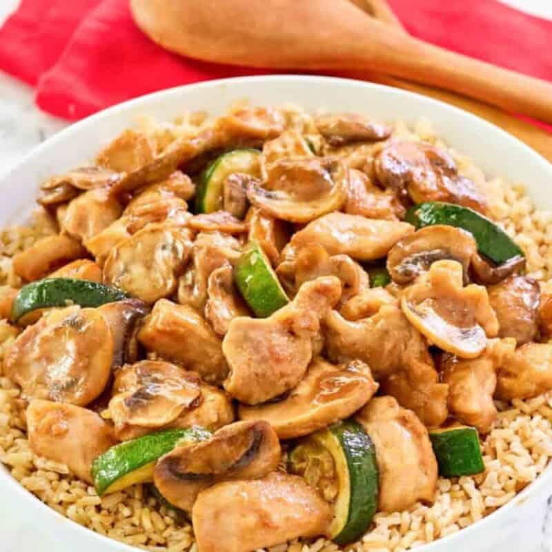 Chicken, mushrooms, zucchini, and rice in a bowl.