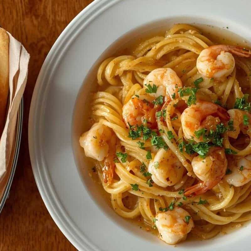 Olive Garden shrimp scampi with pasta and breadsticks.