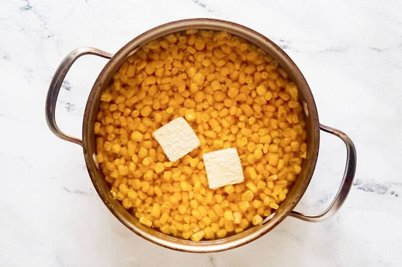 Corn kernels, butter, salt, and water in a pot.