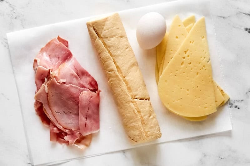 Deli ham, Swiss cheese slices, crescent roll dough, and an egg.