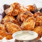 Dipping sauce and dry rub smoked chicken wings in a serving basket.