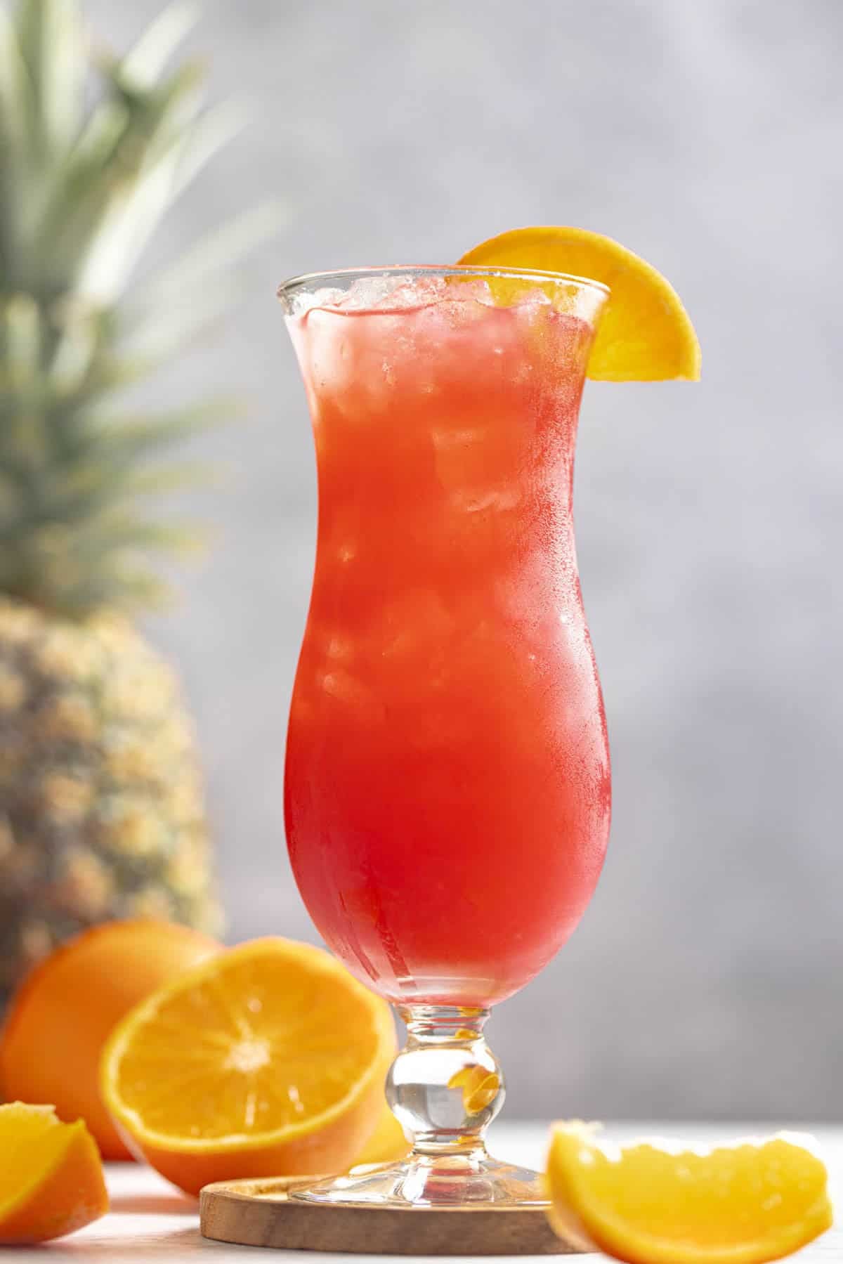 A fruity rum punch drink in a hurricane glass.