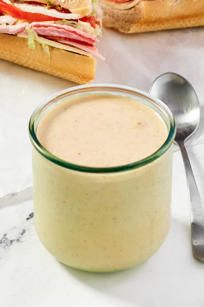Hot ranch sauce in a jar and a spoon next to it.