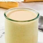 A jar of spicy ranch dressing on a marble surface.