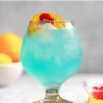 Copycat Texas Roadhouse Kenny's Cooler cocktail garnished with a cherry and orange slice.