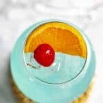 Copycat Texas Roadhouse Kenny's Cooler cocktail garnished with an orange slice and cherry.