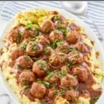 Mississippi meatballs and gravy over mashed potatoes on a platter.