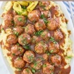Mississippi meatballs and gravy served over mashed potatoes on a platter.