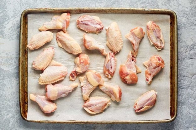 Chicken wingettes and drumettes on a baking sheet.