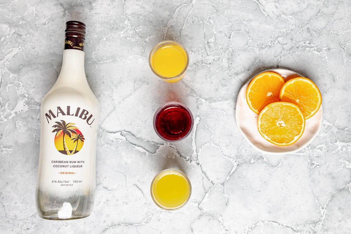Malibu rum, orange juice, pineapple juice, cranberry juice, and orange slices.