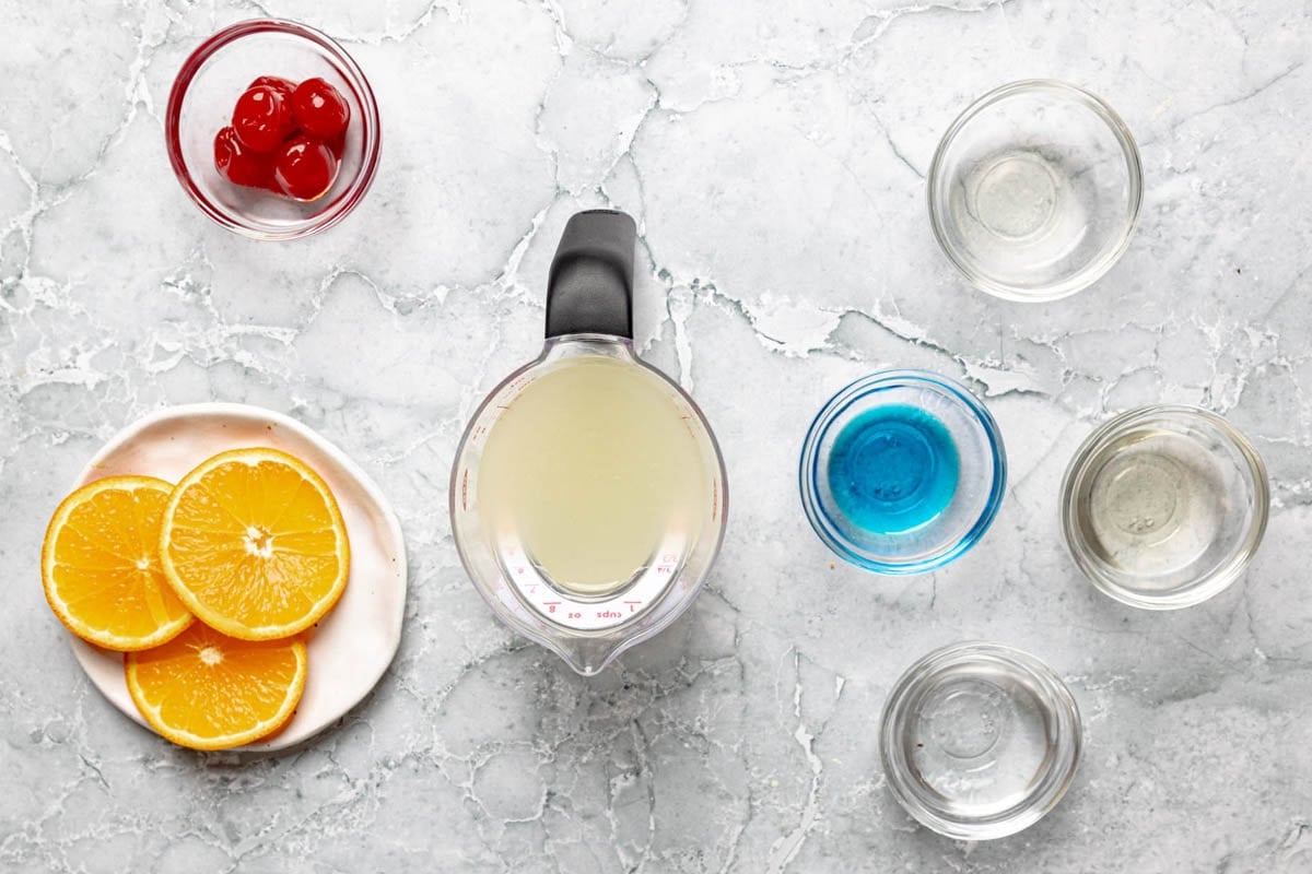 Rum, peach schnapps, blue curacao, sweet and sour mix, orange slices, and cherries.