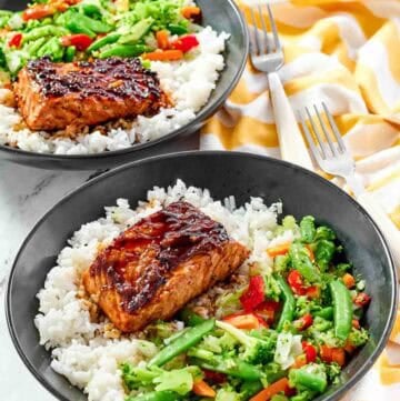 White rice topped with stir-fried veggies and salmon with teriyaki sauce.