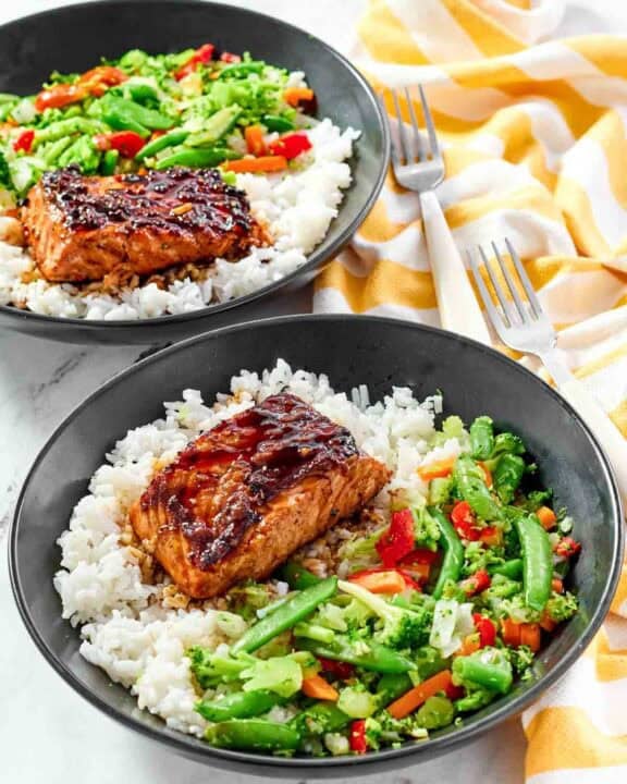 White rice topped with stir-fried veggies and salmon with teriyaki sauce.
