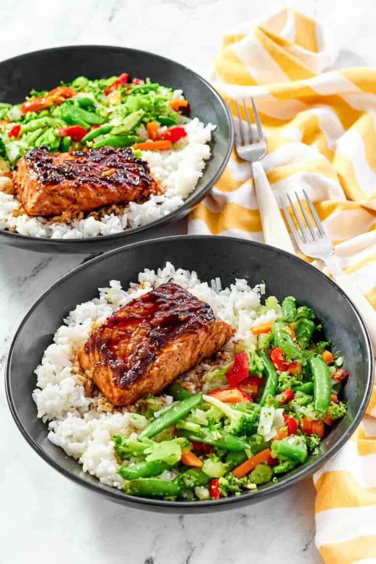 White rice topped with stir-fried veggies and salmon with teriyaki sauce.