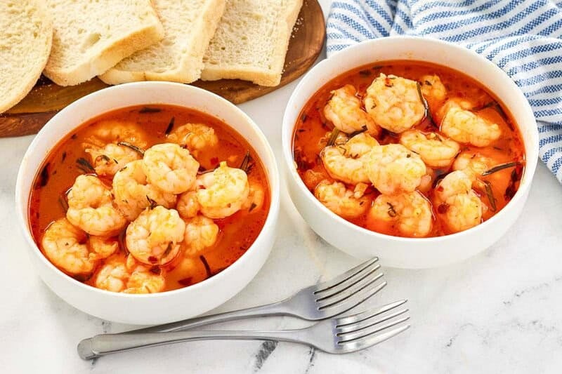 Shrimp in tomato herb broth served with bread.