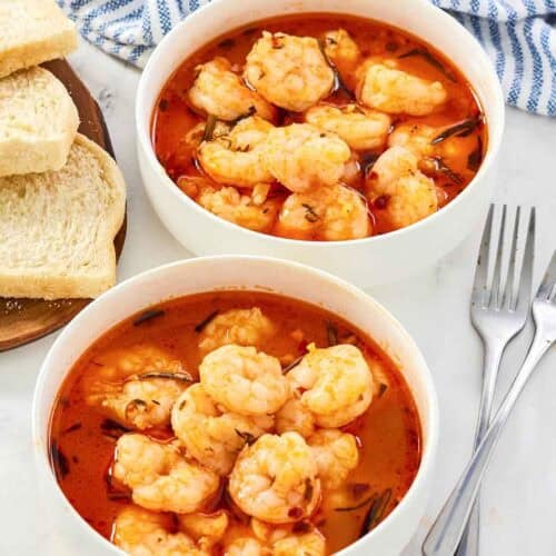 Shrimp served in a buttery herb tomato broth with bread.