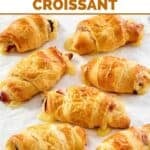 Ham and Swiss cheese crescent rolls on parchment paper.