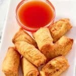 Homemade red sweet and sour sauce served with egg rolls.