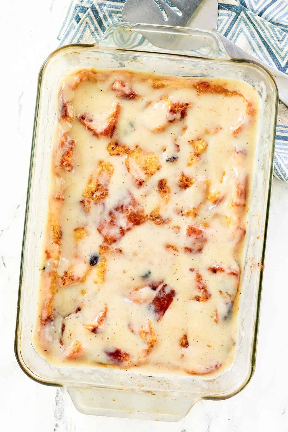 Baked bread pudding topped with creamy nutmeg sauce ready to serve.