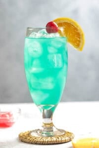 A blue curacao coconut rum cocktail served in a tall glass.