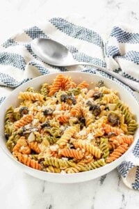 A bowl of feta, artichoke heart, and olive pasta salad.