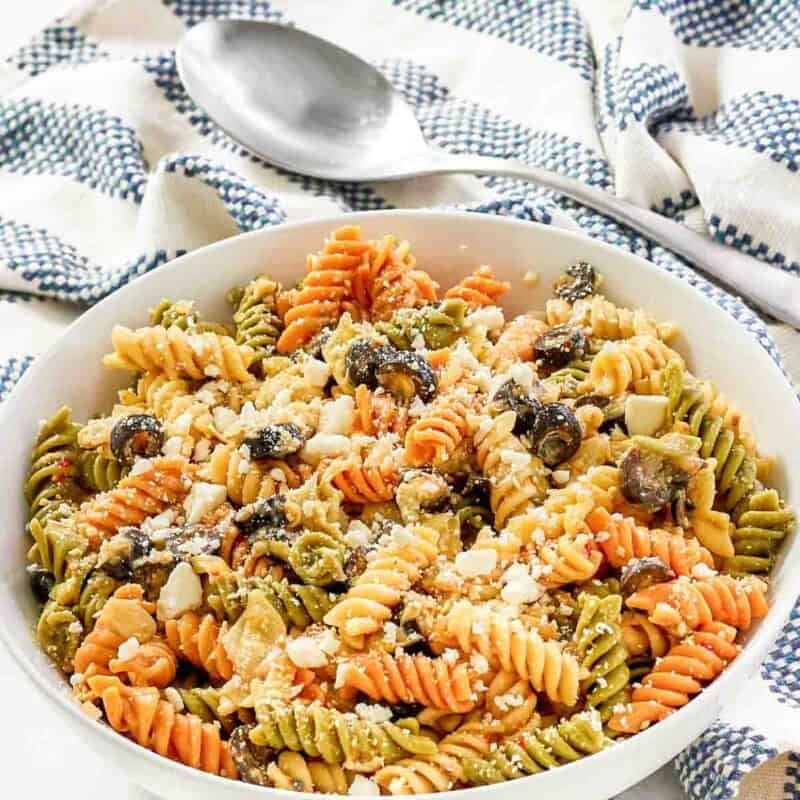 A bowl of feta, artichoke heart, and olive pasta salad.