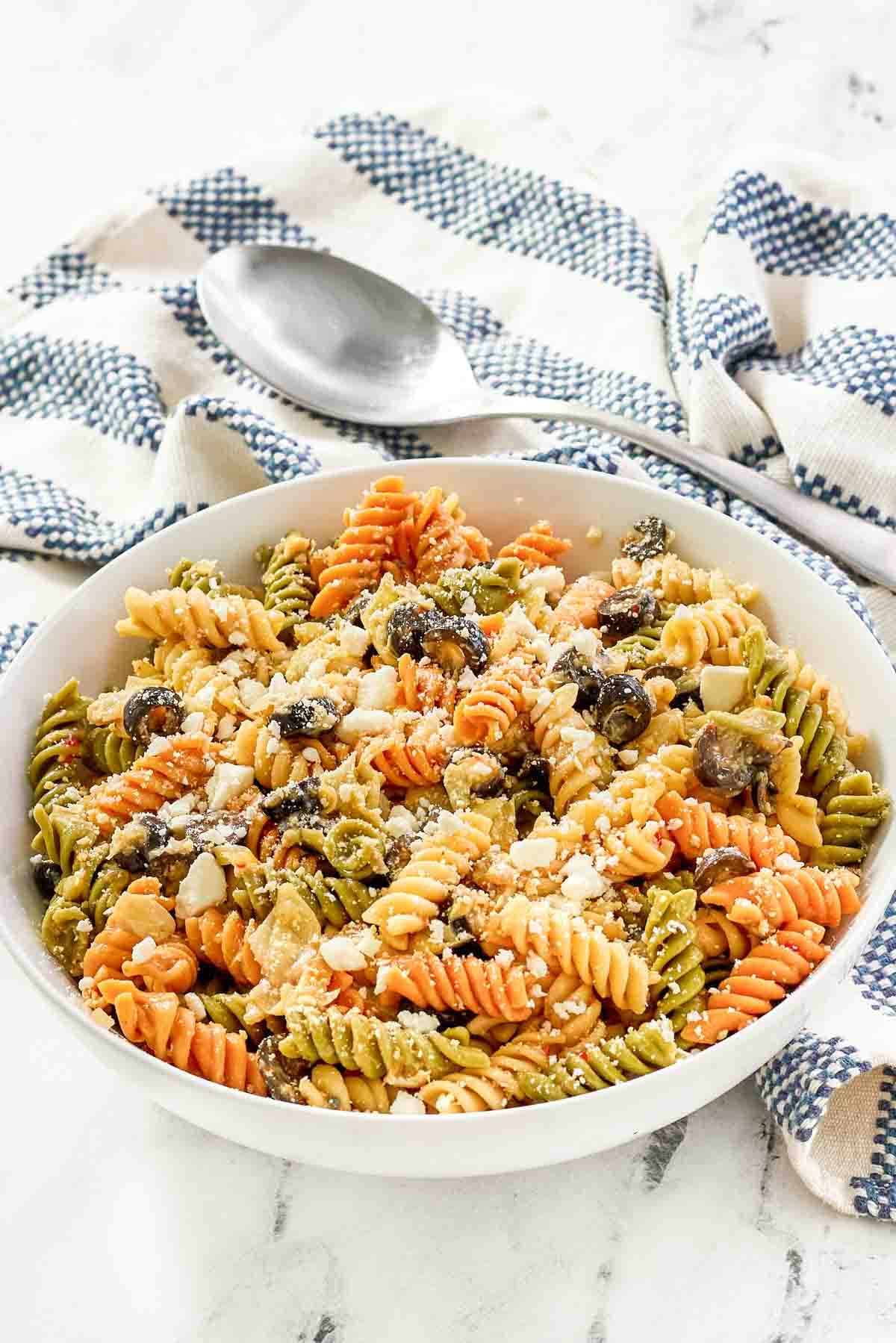 A bowl of feta, artichoke heart, and olive pasta salad.