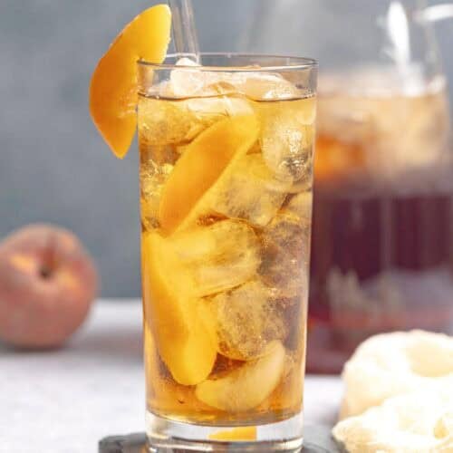 Iced tea made with fresh peach syrup and served with peach slices.