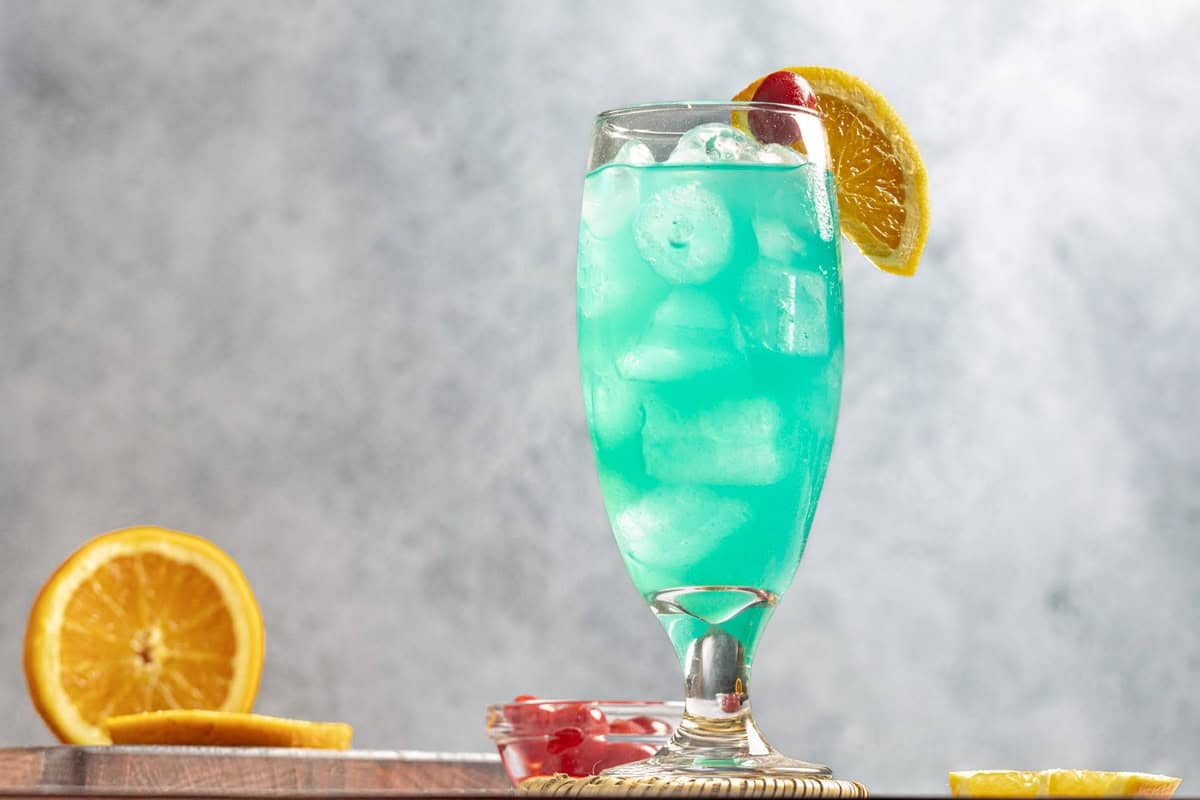 A fruity blue curacao drink in a tall glass.